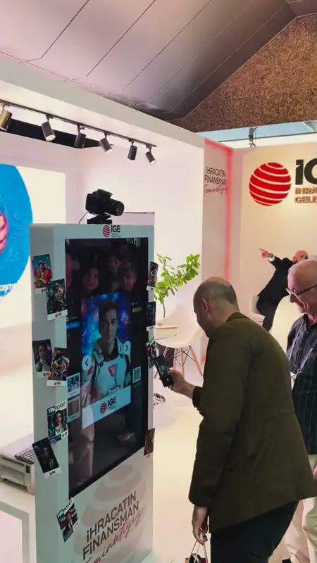 Fuar standında yapay zekâ ile dönüştürülmüş portreyi gösteren dikey AI photo booth totemi