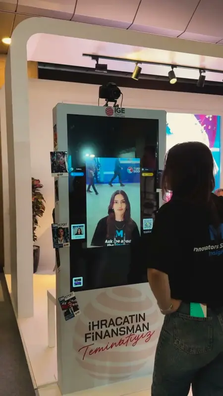 Fuar standında dikey AI photo booth ekranında beliren dönüştürülmüş portre ve QR kod