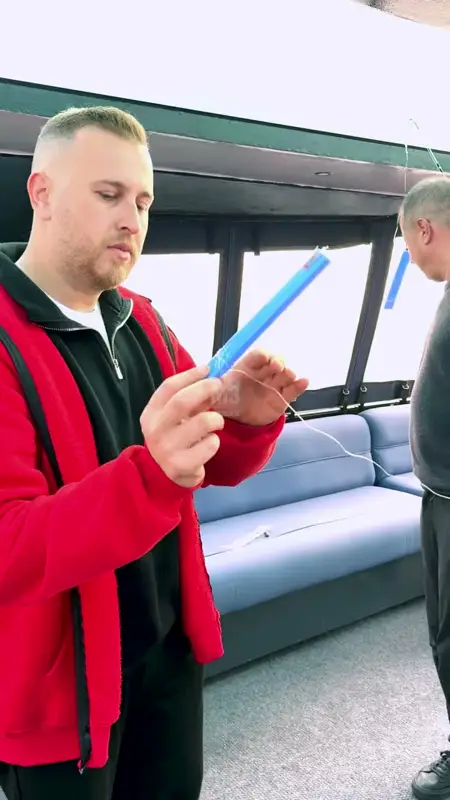 Tekne kabininde mavi makaradan misina çözen katılımcı