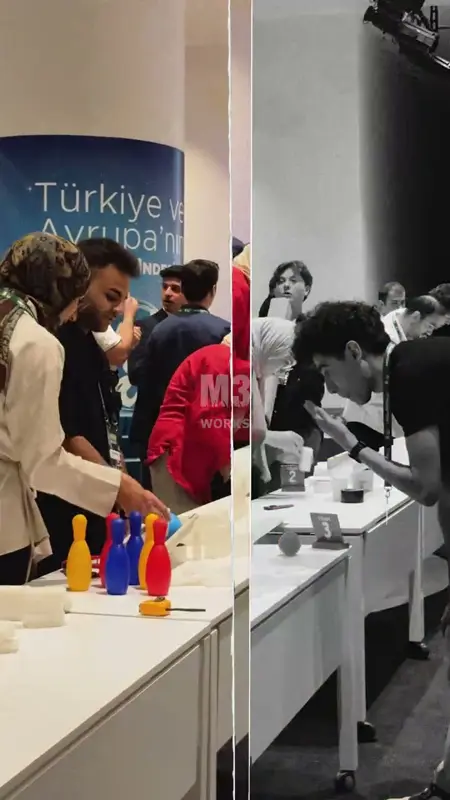 Uzun beyaz masalarda lobut, top ve domino taşlarıyla düzenek kuran takımlar
