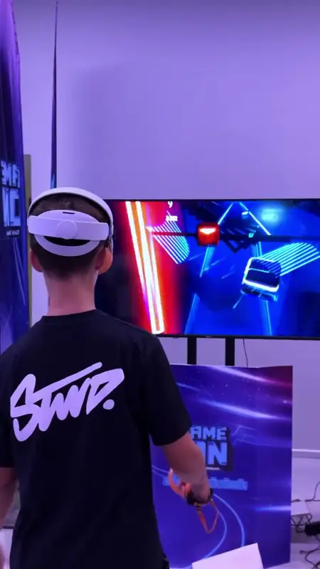 VR gözlük takmış katılımcının ekranda ritim oyunu oynaması