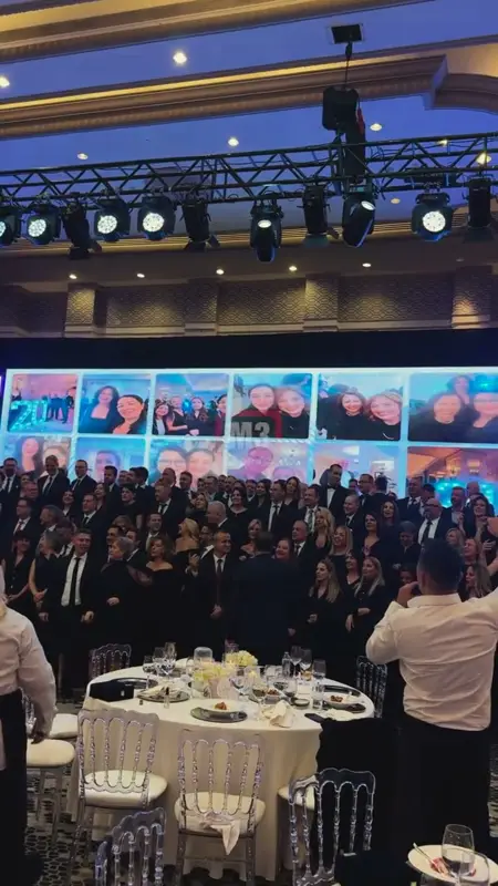 Gala salonunda dev fotoğraf duvarının önünde toplu fotoğraf veren kalabalık