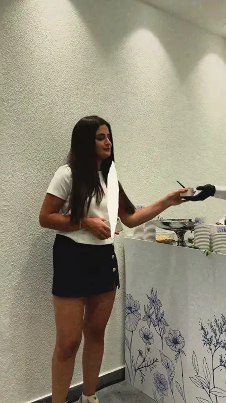 Çiçek desenli beyaz stanttan dondurma kâsesini teslim alan misafir