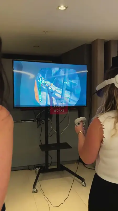 VR gözlük takan katılımcı ve ekrana yansıyan sanal gerçeklik oyunu