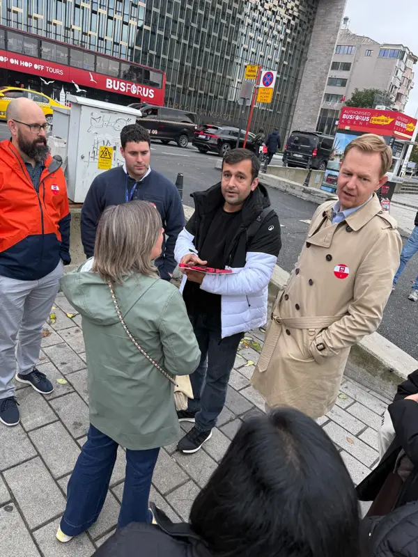 Taksim'de tabletle takıma brifing veren M3 Works görevlisi ve rozetli katılımcılar