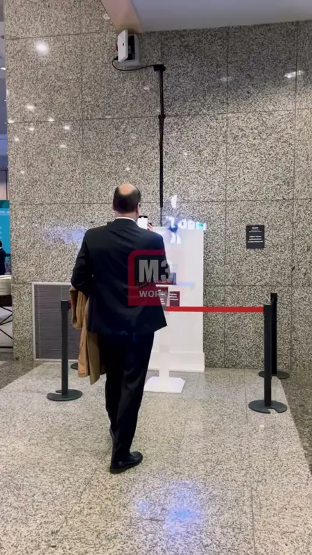 Granit duvarlı fuayede kordonlu bariyerin arkasındaki hologram kurulumuna yaklaşan misafir