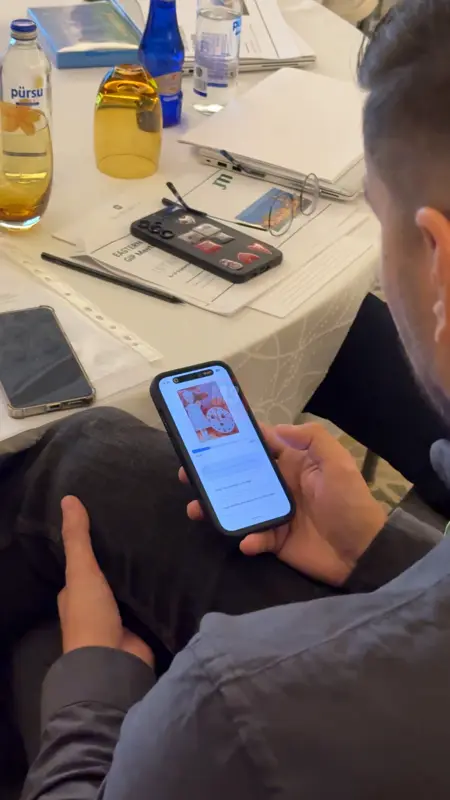 Toplantı masasında telefonundan oy veren katılımcı