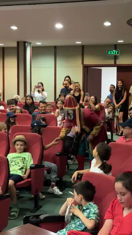 A costumed actor stepping between the seats to shake hands with children
