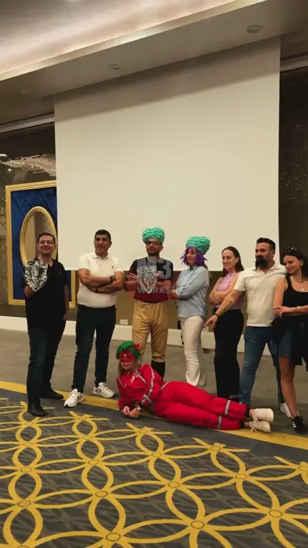 Otel salonunda kostümlü bir takım etkinliğinin sonunda poz veren katılımcılar