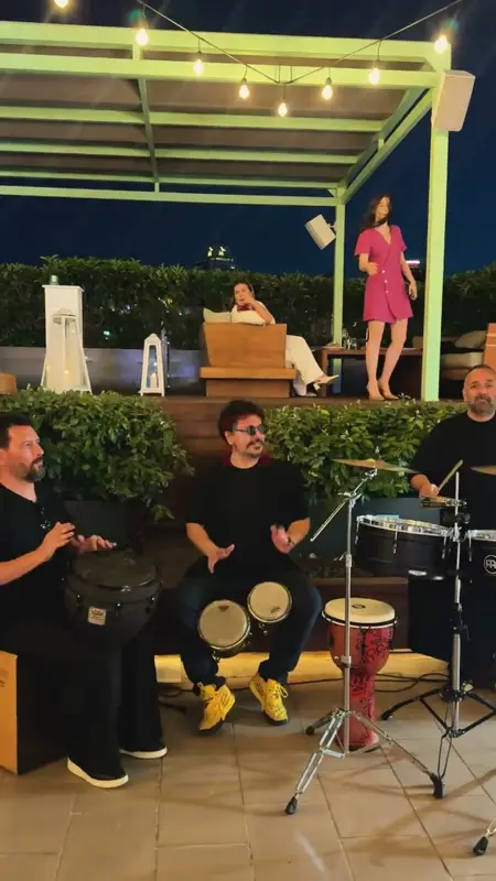 Çatı terasında bongo, djembe ve timbales çalan perküsyon ekibi ve vokal