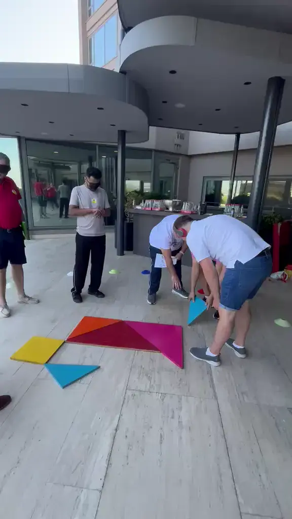 Terasta dev tangram parçalarını birleştirmeye çalışan takım