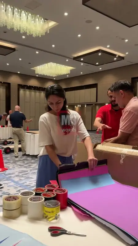 Masada renkli kartonları ölçüp kesen takım üyeleri