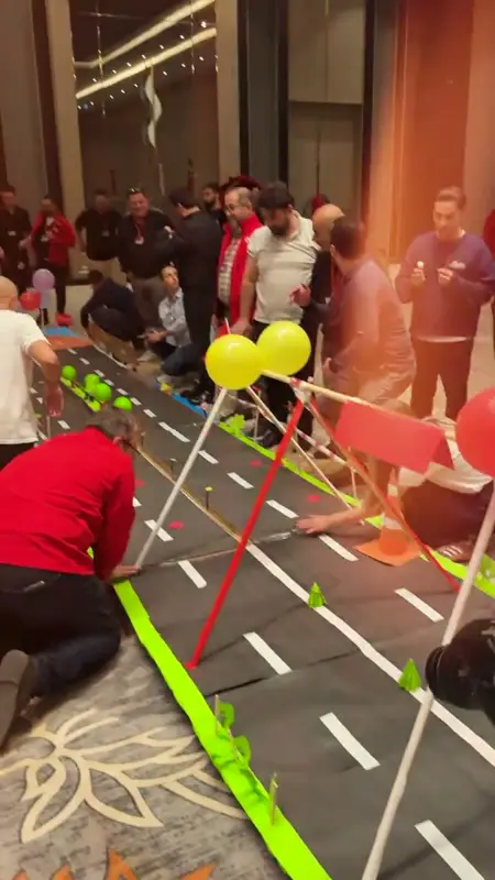 Otel salonunda şeritli ve balonlu otoyol parçalarının başında takımlar