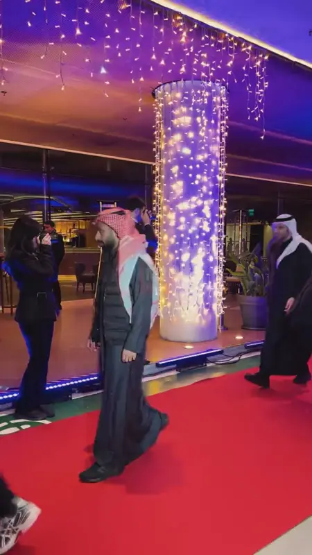 Guests walking the red carpet past illuminated columns