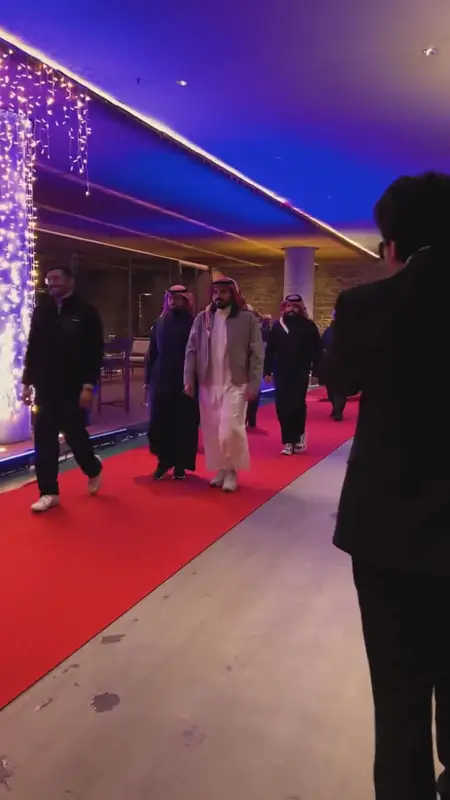 A group of guests walking past photographers into the hall