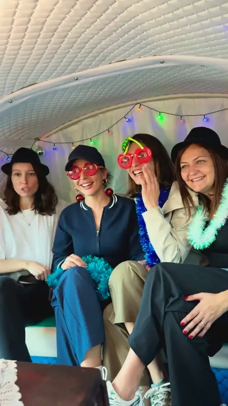 A group posing inside the photo bus with hats, coloured glasses and tinsel