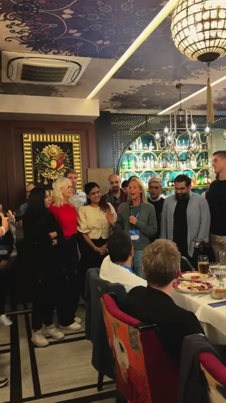 International group standing together at dinner in a restaurant