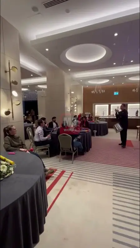 Ritim lideri davulla yuvarlak masalar arasında dolaşıyor