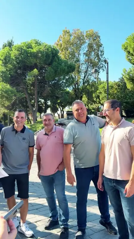 Tarihi parkta güneşli bir günde poz veren takım üyeleri