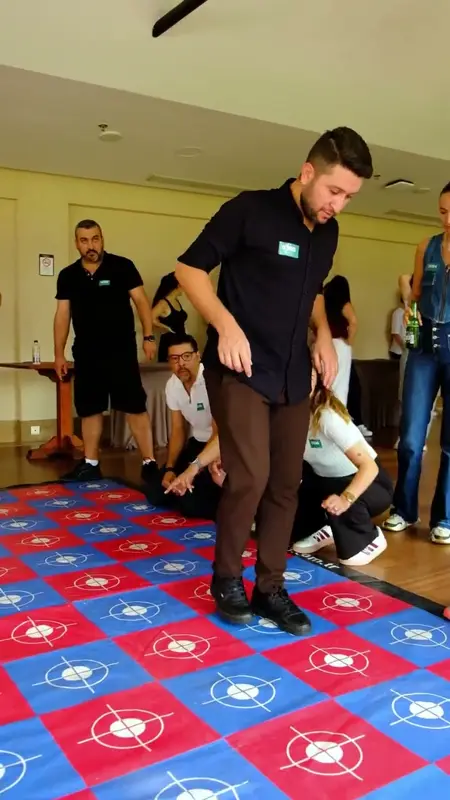 Kırmızı mavi cam köprü matında adım atan katılımcı ve izleyen takım arkadaşları